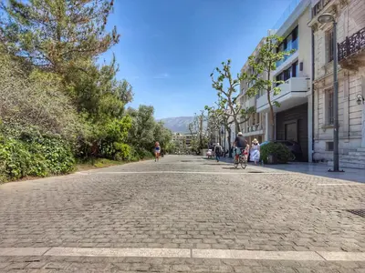 a group of people riding bikes down a street at Under the Rock of Acropolis by YHA in Athens