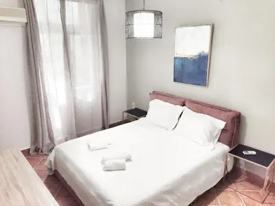a bedroom with a bed with white sheets and white pillows at Under the Rock of Acropolis by YHA in Athens