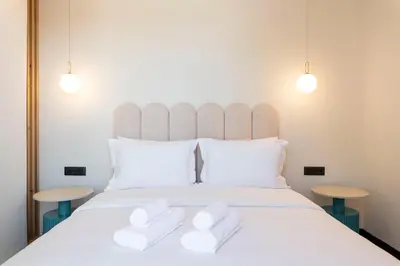 a bedroom with a large white bed with two tables at PAREA Athens in Athens