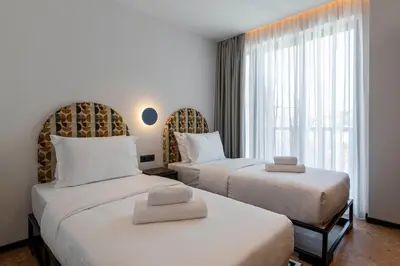 a hotel room with two beds and a window at PAREA Athens in Athens