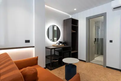 a living room with a couch and a table and a mirror at PAREA Athens in Athens