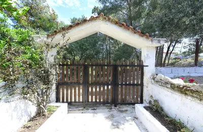 an entrance to a gate with a fence with a wooden gate at Marin Holiday in Dhaskalión
