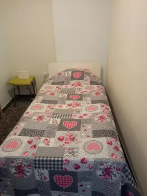 a bed with a quilt on it in a room at JiMMYS STUDIO, KALIMARMARO in Athens