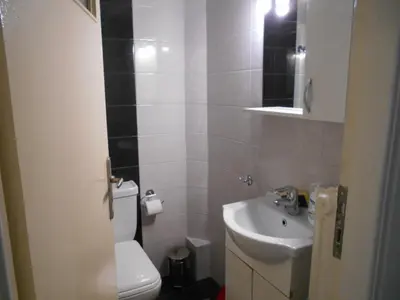 a bathroom with a white toilet and a sink at JiMMYS STUDIO, KALIMARMARO in Athens