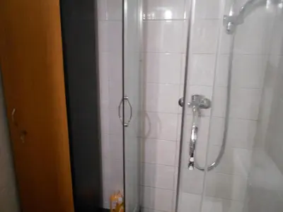 a shower with a glass door in a bathroom at JiMMYS STUDIO, KALIMARMARO in Athens