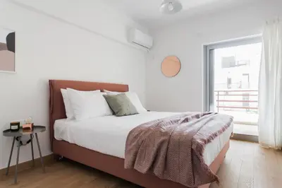a white bedroom with a large bed and a window at Stellar 3BR Apartment with Balcony by UPSTREET in Athens