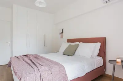 a bedroom with a large bed with white pillows at Stellar 3BR Apartment with Balcony by UPSTREET in Athens