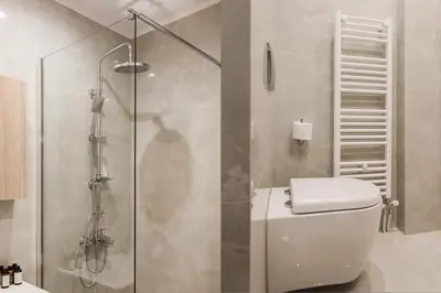 a bathroom with a toilet and a glass shower at Stellar 3BR Apartment with Balcony by UPSTREET in Athens