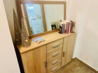 a wooden dresser with a mirror and books on it at Royal Blue Grand Suite No 1 in Piraeus