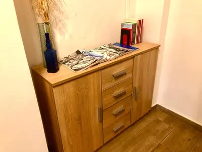 a wooden cabinet in a room with books on it at Royal Blue Grand Suite No 1 in Piraeus