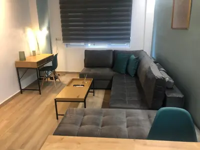 a living room with a couch and a table at Royal Blue Grand Suite No 1 in Piraeus