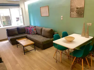 a living room with a couch and a table at Royal Blue Grand Suite No 1 in Piraeus