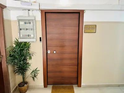 a wooden door in a hallway with a plant at Royal Blue Grand Suite No 1 in Piraeus