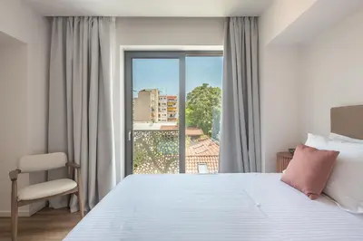a bedroom with a white bed and a window at Ceramian Athens in Athens