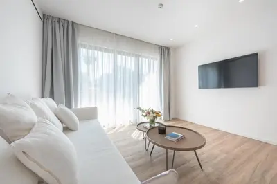 a white living room with a white couch and a table at Ceramian Athens in Athens