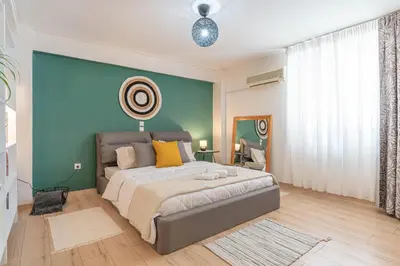 a bedroom with a large bed and a green wall at Boho Chic Apartment Under Acropolis in Athens