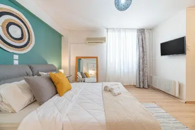 a living room with a large bed and a tv at Boho Chic Apartment Under Acropolis in Athens