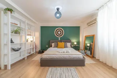 a bedroom with a bed and a green wall at Boho Chic Apartment Under Acropolis in Athens