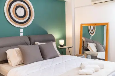 a bedroom with a large white bed with a mirror at Boho Chic Apartment Under Acropolis in Athens