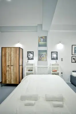 a white bedroom with a large bed with two pillows at The old Tailor Factory White Room in Athens