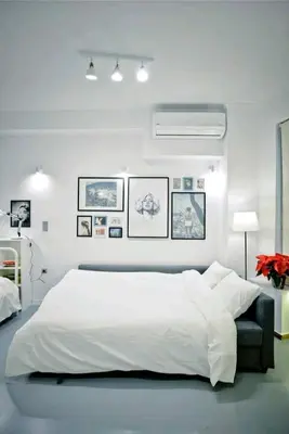 a white bedroom with a large bed and pictures on the wall at The old Tailor Factory White Room in Athens