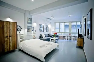 a white bedroom with a bed and a living room at The old Tailor Factory White Room in Athens