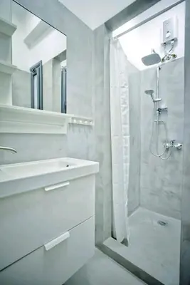 a white bathroom with a shower and a sink at The old Tailor Factory White Room in Athens