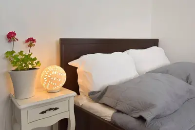 a bed with a table with a plant on it at Cozy Bright Studio in Athens