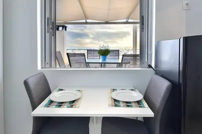 a dining room table with two chairs and a window at Cozy Bright Studio in Athens