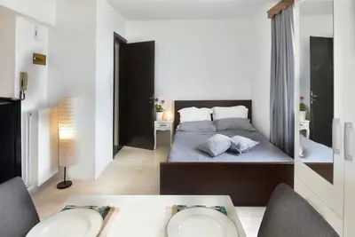 a bedroom with a bed and a table with chairs at Cozy Bright Studio in Athens