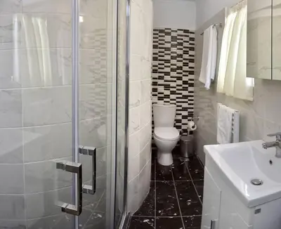 a bathroom with a shower and a toilet and a sink at Cozy Bright Studio in Athens