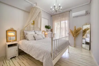 a bedroom with a white bed and a chandelier at Luxury Apartment Marina Zeas Piraeus - Balcony - Near Port in Piraeus