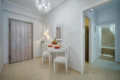a dining room with a white table and chairs at Luxury Apartment Marina Zeas Piraeus - Balcony - Near Port in Piraeus