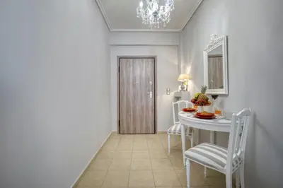 a dining room with a table and chairs and a chandelier at Luxury Apartment Marina Zeas Piraeus - Balcony - Near Port in Piraeus