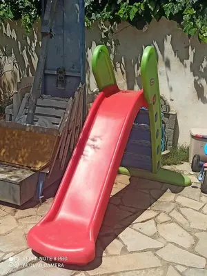 a red and green slide on a playground at Cozy Studio in Athens
