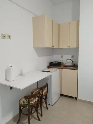 a kitchen with two chairs and a white refrigerator at Cozy Studio in Athens