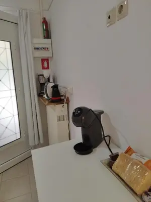 a kitchen with a white counter with a black appliance on it at Cozy Studio in Athens