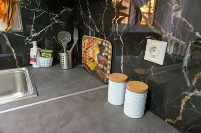 a kitchen counter with a sink and three paper cups at Alimos - Sea View Apartment in Athens