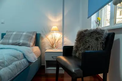 a bedroom with a bed and a chair and a lamp at Alimos - Sea View Apartment in Athens