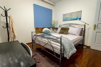 a bedroom with a bed and a table at Alimos - Sea View Apartment in Athens