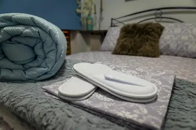 a bed with a pillow and a phone on it at Alimos - Sea View Apartment in Athens