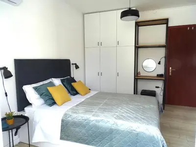 a bedroom with a bed with yellow and green pillows at Zeus Bright & New Apartment - 25' walk to the Acropolis in Athens