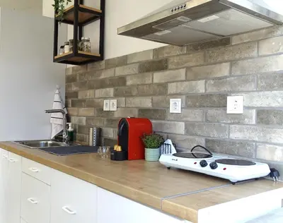 a kitchen counter with a stove and a sink at Zeus Bright & New Apartment - 25' walk to the Acropolis in Athens