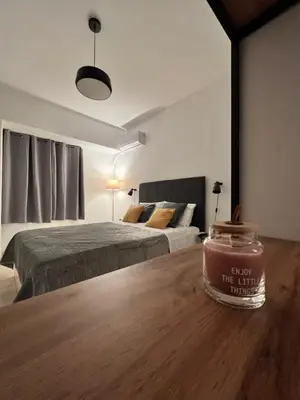 a bedroom with two beds and a jar on a wooden table at Zeus Bright & New Apartment - 25' walk to the Acropolis in Athens
