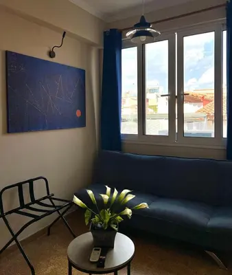 a living room with a blue couch and a table at Monastiraki 510 SuperHost Hub in Athens