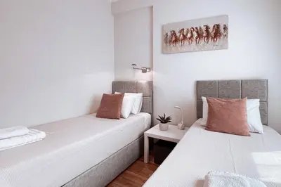 two beds in a small room with white walls at Penthouse - Amazing View in the Center of Athens in Athens