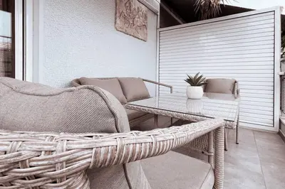 a wicker chair and a table on a porch at Penthouse - Amazing View in the Center of Athens in Athens