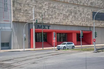 a white car parked in front of a red building at Penthouse - Amazing View in the Center of Athens in Athens