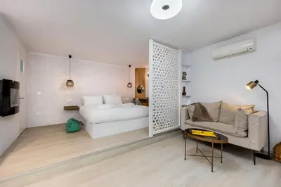 a bedroom with a bed and a couch in a room at Seaside Nestie by BluPine in Athens