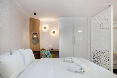 a bedroom with a white bed with towels on it at Seaside Nestie by BluPine in Athens